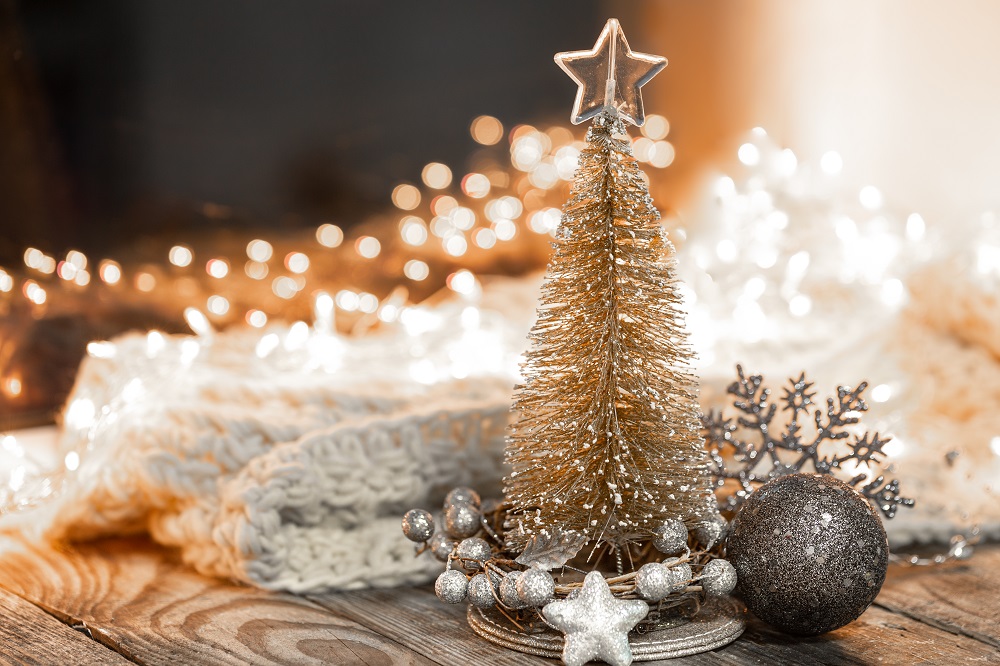 Christmas composition with a decorative tree, details of a festive decor on a blurred background with bokeh lights, copy space.
